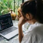 Woman Looking at Cryptocurrency Charts on Her Laptop