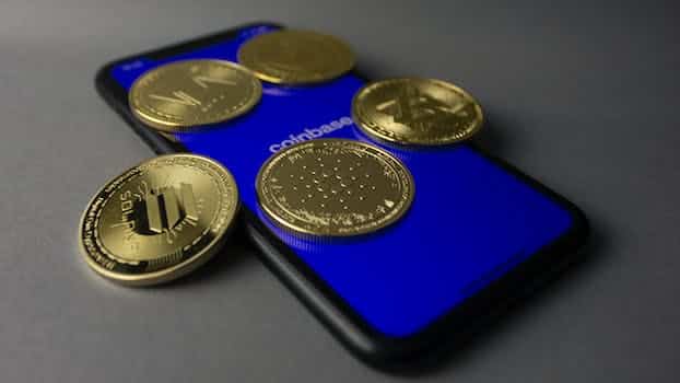 Studio Shot of Gold Bitcoins Lying on Top of a Smart Phone