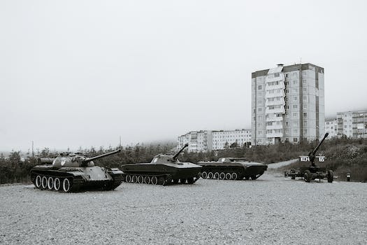 Black and white of monuments of various military vehicles on square in city