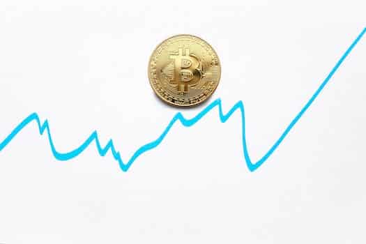 Gold bitcoin cryptocurrency coin and blue graph of changes of value on white background