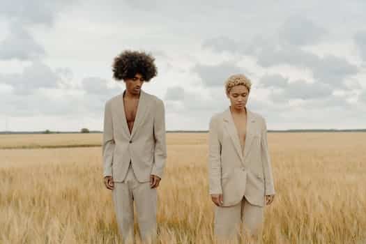 Man and Woman in Beige Suit Standing on Grass Field
